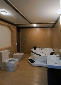 a bathroom with two sinks and a tub and a toilet at Hotel Alsey Krasnoyarsk in Sliznevo