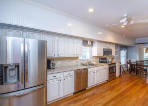 a kitchen with white cabinets and stainless steel appliances at Carpe Beachem in Tybee Island