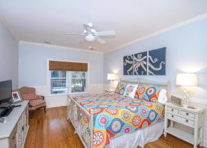 a bedroom with a bed and a ceiling fan at Carpe Beachem in Tybee Island