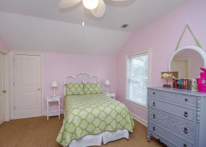 a bedroom with a bed and a dresser and a mirror at Carpe Beachem in Tybee Island