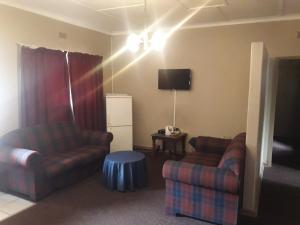 a living room with two couches and a tv at Horseshoe Inn and Conference Center in Kimberley