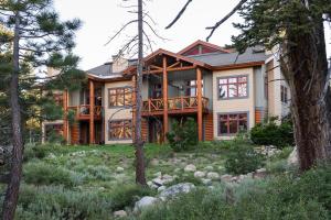a log home with a deck in the woods at Cabins 21 in Old Mammoth