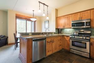 a kitchen with wooden cabinets and stainless steel appliances at Cabins 21 in Old Mammoth