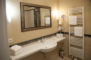 a bathroom with a sink and a mirror at M13 Hotel in Riol +42 photos