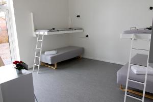 um quarto com 2 beliches e um sofá em Hostel Brønderslev em Bronderslev
