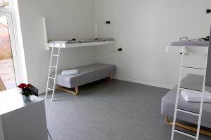 Zimmer mit 2 Etagenbetten und einem Sofa in der Unterkunft Hostel Brønderslev in Brønderslev