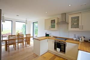 a kitchen and dining room with a table and chairs at Skeabost Wood Cottage in Skeabost