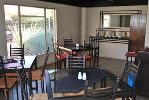 Un restaurante con mesas y sillas en una sala. en LeHiel Guesthouse, en Lichtenburg