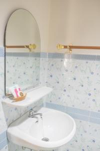 een badkamer met een witte wastafel en een spiegel bij Mountain View House in Sangkhla Buri