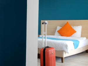 a hotel room with a bed with a red suitcase at Saglam Hôtel in Goussainville