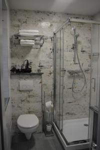 a bathroom with a toilet and a shower with a glass door at Wels Inn Hotel in Wels