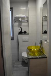 a bathroom with a yellow sink and a toilet at Wels Inn Hotel in Wels