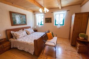 a bedroom with a bed and a chair and windows at Villa Oliva Bribir in Bribir +70 photos