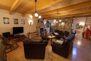 a living room with leather furniture and a stone wall at Villa Oliva Bribir in Bribir