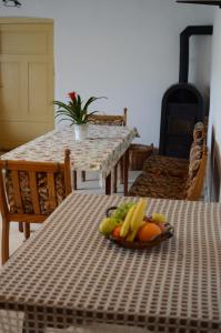 a table with a plate of fruit on top of it at Gerecse Vendégház in Süttő