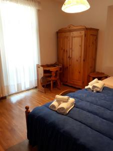 a bedroom with two beds with towels on them at Hotel Fiames in Cortina dʼAmpezzo