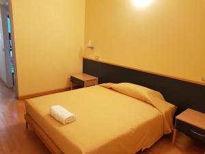 a bedroom with a large bed with a yellow wall at Hotel Le Cardinal in Bastiglia