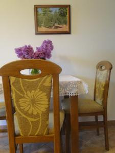 a table and chairs with a vase with purple flowers on it at Villa Agava in Vrboska