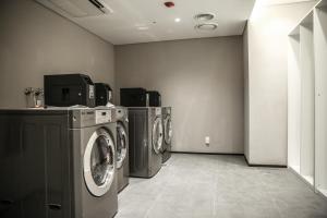 a laundry room with three washing machines in it at GLAD Gangnam COEX Center in Seoul