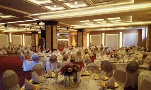 un grupo de personas sentadas en mesas en un salón de banquetes en Chakarova Guest House, en Sliven