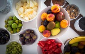 a table topped with bowls of different types of fruit at Island Boutique Hotel in Larnaca