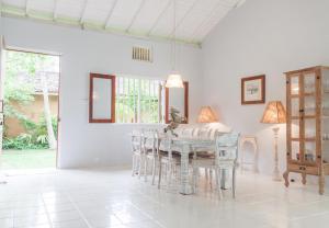 a white dining room with a table and chairs at Bungalow Sud in Habaraduwa Central +10 photos