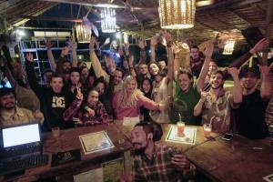 Un gruppo di persone che alza le mani in un bar di Tribal Pai a Pai