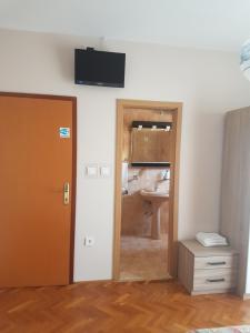 uma casa de banho com um lavatório e uma televisão na parede em Guest House Mrvčić em Rupa