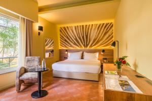 a bedroom with a bed and a desk and a chair at Calheta Beach - All-inclusive - Savoy Signature in Calheta