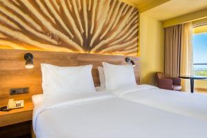 a hotel room with a large bed and a window at Calheta Beach - All-inclusive - Savoy Signature in Calheta