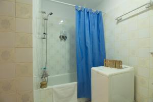 une salle de bain avec un rideau de douche bleu et des toilettes dans l'établissement Apartamento Faro 77, à Torrox Costa 27 autres photos