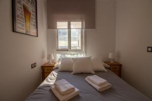 une chambre avec un lit avec deux serviettes dessus dans l'établissement Apartamento Faro 77, à Torrox Costa