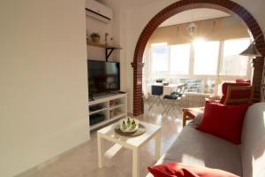 un salon avec un canapé et une télévision dans l'établissement Apartamento Faro 77, à Torrox Costa