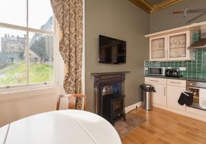 a living room with a table and a fireplace at The Castle Esplanade Residence in Edinburgh