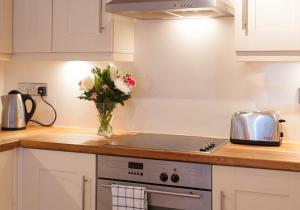 een keuken met een vaas met bloemen op het aanrecht bij The Drummond Street Residence in Edinburgh