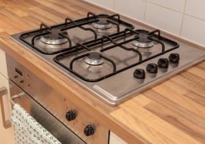 a stove top with four burners on a kitchen counter at The Edmonstone's Close Residence in Edinburgh