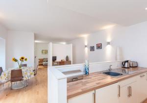 uma cozinha com um lavatório e uma mesa num quarto em The Edmonstone's Close Residence em Edimburgo