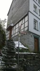 um sinal de rua em frente a um edifício com neve em Haus am Oberen Mühlenberg mit GARTENNUTZUNG em Monschau