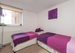 Duas camas sentadas uma ao lado da outra num quarto em The Metropole Residence em Glasgow