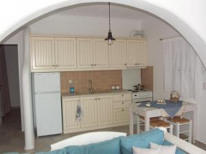 ナクソス・コラにあるKarades Houses Poseidon 75m2の白い冷蔵庫とテーブルのあるキッチン +38枚の写真