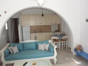 a living room with a blue couch and a kitchen at Karades Houses Poseidon 75m2 in Naxos Chora