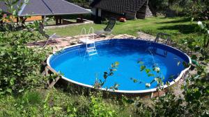 a swimming pool in the yard with two chairs and a ladder in it at Chaloupka u potoka in Svetla Hora