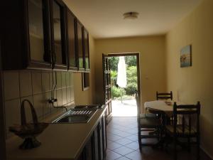 a kitchen with a sink and a table and a door at Villa Agava in Vrboska