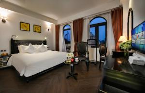 1 dormitorio con 1 cama, escritorio y TV en Hanoi Center Silk Premium Hotel & Spa & Travel en Hanoi