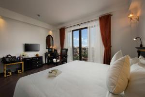 a bedroom with a large white bed and a window at Hanoi Center Silk Premium Hotel & Spa & Travel in Hanoi