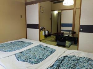 1 dormitorio con 2 camas, escritorio y espejo en Hotel Edoya en Tokio