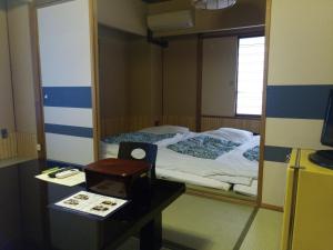 1 dormitorio con espejo y escritorio con cama en Hotel Edoya, en Tokio