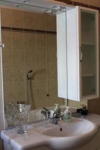 ein Waschbecken mit einem Schrank und einem Spiegel in der Unterkunft B. & B. NABUCCO in Parma