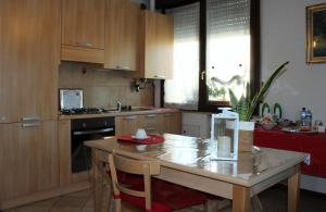 a kitchen with wooden cabinets and a table with chairs at B. & B. NABUCCO in Parma