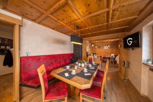 ein Esszimmer mit einem roten Sofa und einem Tisch in der Unterkunft Haus Gollas in Sankt Anton am Arlberg